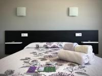 A bed or beds in a room at Dukes Habitaciones