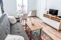 ein Wohnzimmer mit einem Sofa und einem Tisch in der Unterkunft Cosy 2 pièces aux Portes de Paris in Clichy