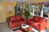 two red chairs and a table on a porch at Hotel Villa Ruscello in Baveno