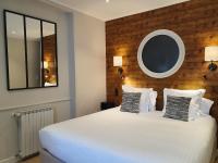 A bed or beds in a room at Logis Hotel La Closerie