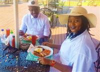 una mujer sentada en una mesa con un plato de comida en Crocodile Pools Resort, en Gaborone