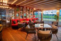 een restaurant met een rode bank en tafels en stoelen bij Aparthotel Paradiso in Nesebar