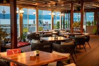 een restaurant met tafels en stoelen en uitzicht op de oceaan bij Aparthotel Paradiso in Nesebar