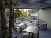 una zona de estar al aire libre con mesas, sillas y una ventana en Eventhotel Ö - Cappuccino, en Geiselwind