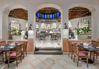 a restaurant with tables and chairs in a room at Iberotel Makadi Beach in Hurghada