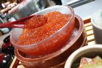 un bol de madera lleno de salsa naranja con una cuchara roja en Dormy Inn Premium Otaru, en Otaru