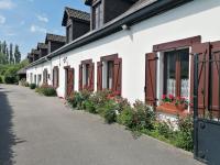 eine Reihe weißer Gebäude mit Blumentopfen und Fenstern in der Unterkunft La longére fleurie in Cucq