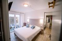 a bedroom with a white bed and a balcony at Hotel Atlantique in Mimizan-Plage