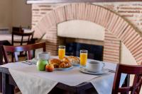 a table with a breakfast of bread and orange juice at Hotel Atlantique in Mimizan-Plage
