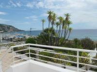 a balcony with palm trees and a view of the ocean at Appartement Menton, 3 pièces, 5 personnes - FR-1-196-290 in Menton
