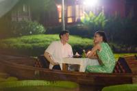 Ma Doo Bua Stay - SHA Extra Plus في تالانغ: رجل وامرأة يجلسان على طاولة في قارب