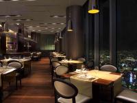 大阪市にある大阪マリオット都ホテルのテーブルと椅子があり、街の景色が見えるレストラン