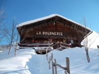 a log cabin in the snow with a sign on it at La Bournerie in Le Grand-Bornand