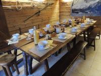 a long wooden table with chairs and food on it at La Bournerie in Le Grand-Bornand