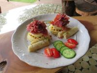 a plate of food with waffles and vegetables on a table at Wild Dog Guest Lodge in Hoedspruit