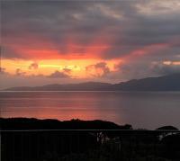 a sunset over a body of water with mountains at Les Rivages de Stagnola Appartement T3 vue mer et montagne plage 200m climatisé in Pietrosella