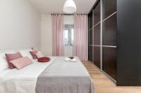 a bedroom with a large white bed with pink pillows at Apartman Olea in Pula