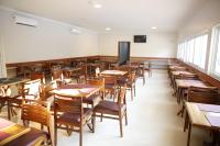 an empty classroom with wooden tables and chairs at Hotel Uipi in Sorriso