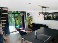 a kitchen and living room with a black counter top at Le Ristouar Spa forêt et mer in Quimperlé