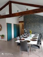 une grande salle à manger avec une table et des chaises blanches dans l&#39;établissement ferme de fenivou, à Boulieu-lès-Annonay