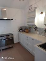 - une cuisine avec des placards blancs et une cuisinière dans l&#39;établissement ferme de fenivou, à Boulieu-lès-Annonay