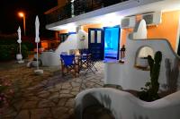 a patio with a table and chairs at night at Alisaxni Studios in Argassi