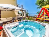 a hot tub in a backyard with a slide at Holiday Home Villa Orhidea by Interhome in (( Marčići ))