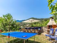 a ping pong table with chairs and an umbrella at Holiday Home Villa Orhidea by Interhome in (( Marčići ))
