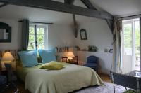 a bedroom with a bed with a yellow pillow on it at Aux Rives de Honfleur in Berville-sur-Mer