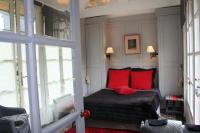 a bedroom with a bed with red pillows at Aux Rives de Honfleur in Berville-sur-Mer