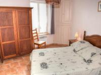 a bedroom with a bed and a wooden cabinet at Gîte Montrésor, 4 pièces, 7 personnes - FR-1-381-72 in Montrésor