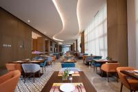 a dining room with tables and chairs and windows at Holiday Inn Express Chengdu Longquanyi North by IHG in Chengdu