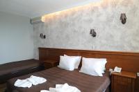A bed or beds in a room at Petrov Family Hotel