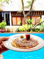 a person holding a plate of food on a table at Pousada Arte Urquijo in Paraty