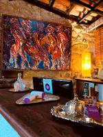 a bar with a painting on the wall and a table at Pousada Arte Urquijo in Paraty