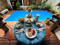 a table with food on it next to a swimming pool at Pousada Arte Urquijo in Paraty