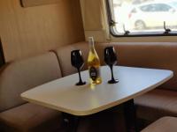 ein Tisch mit zwei Gläsern und einer Flasche Wein in der Unterkunft Caravan In the Desert in Eilat