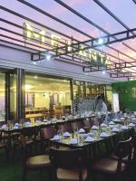 Un comedor con mesas y sillas y una lámpara de araña. en Melanta Hotel - FLC Sầm Sơn, en Sầm Sơn