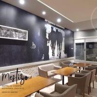 Un restaurante con mesas y sillas y una pared negra. en Mestizo Hotel, en Lincoln