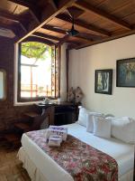 a bedroom with a large bed and a window at Pousada Arte Urquijo in Paraty