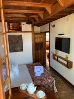 a room with a bed and a flat screen tv at Pousada Arte Urquijo in Paraty