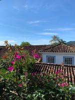 a house with pink flowers in front of a roof at Pousada Arte Urquijo in Paraty