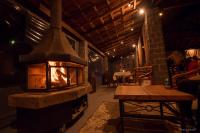 een stenen open haard in een kamer met een tafel bij Rancho do Zé João in Lavrinhas