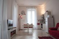 Una sala de estar con un televisor y una mesa con sillas. en Principe Apartment, en Génova