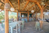 un ristorante con un grande tavolo e sedie e un bar di Chloe Apartments a Lixouri