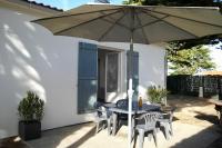 - une table et des chaises sous un parasol sur la terrasse dans l&#39;établissement Charmante maison à 500 m du Remblais de Notre-Dame-de-Monts, à Notre-Dame-de-Monts