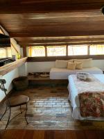 a bedroom with a large bed and a window at Pousada Arte Urquijo in Paraty