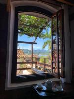 a window in a house looking out at a view at Pousada Arte Urquijo in Paraty