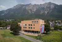 a brick building with mountains in the background at Schaan-Vaduz Youth Hostel in Schaan