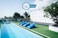 una piscina con almohadas azules junto a un edificio en BearPacker Patong Hostel, en Patong Beach